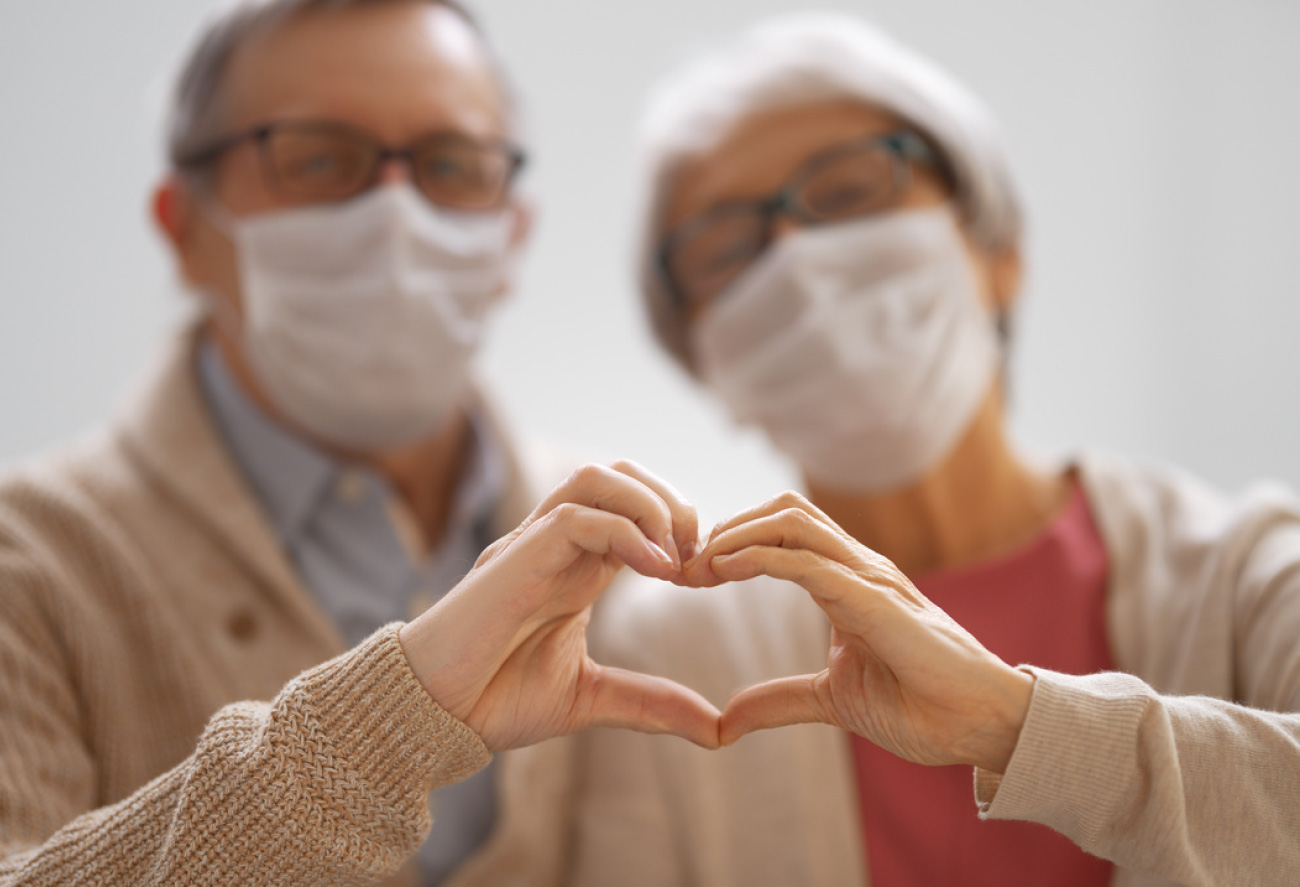 Elderly couple making heart shape together with hands
